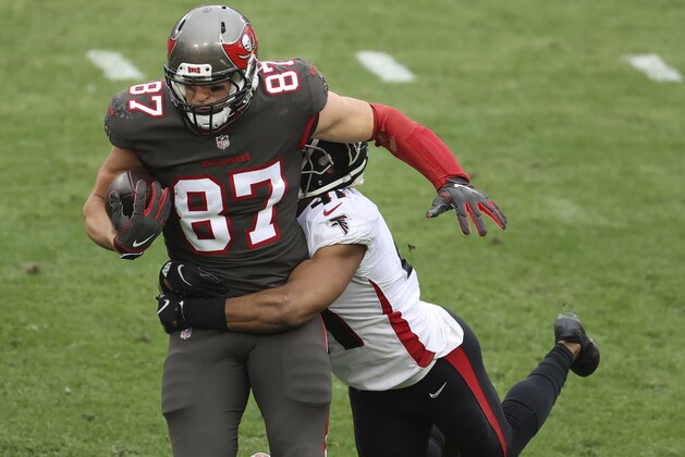 Tampa Bay Buccaneers tight end Rob Gronkowski (87) carries Atlanta Falcons safety Sharrod Neasman (41) after a catch during the second half of an NFL football game Sunday, Jan. 3, 2021, in Tampa, Fla. (AP Photo/Mark LoMoglio)
