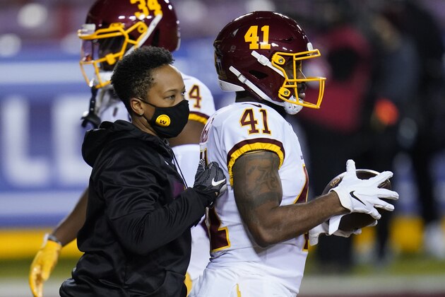 Washington Football Team full-year coaching intern Jennifer King talking with running back J.D. McKissic (41) on the field before the start of an NFL wild-card playoff football game against the Tampa Bay Buccaneers, Saturday, Jan. 9, 2021, in Landover, Md. (AP Photo/Julio Cortez)
