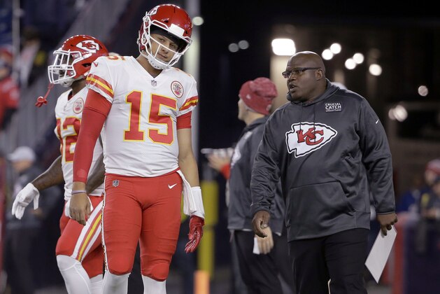 FILE - In this Oct. 14. 2018, file photo, Kansas City Chiefs quarterback Patrick Mahomes listens to offensive coordinator Eric Bieniemy, right, as he warms up for the team's NFL football game against the New England Patriots in Foxborough, Mass. The Miami Dolphins have begun their search for a coach who’s ready to lose this year. New England Patriots linebackers coach Brian Flores and Bieniemy, the first candidates to interview for the Dolphins’ job, met with them Friday, Jan. 4. Owner Stephen Ross is seeking a replacement for Adam Gase, and wants to rebuild after a 7-9 season. (AP Photo/Steven Senne)
