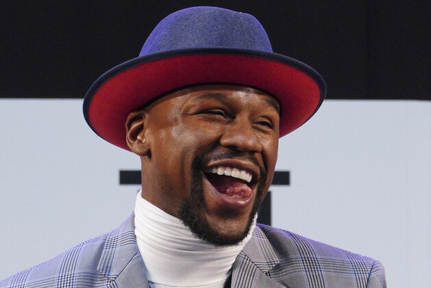 Floyd Mayweather Jr. smiles as Japanese kickboxer Tenshin Nasukawa speaks after their official weigh-in ceremony during a news conference in Saitama, north of Tokyo Sunday, Dec. 30, 2018. Mayweather is scheduled to fight in a three-round exhibition match in Japan on New Year's Eve. (AP Photo/Eugene Hoshiko)