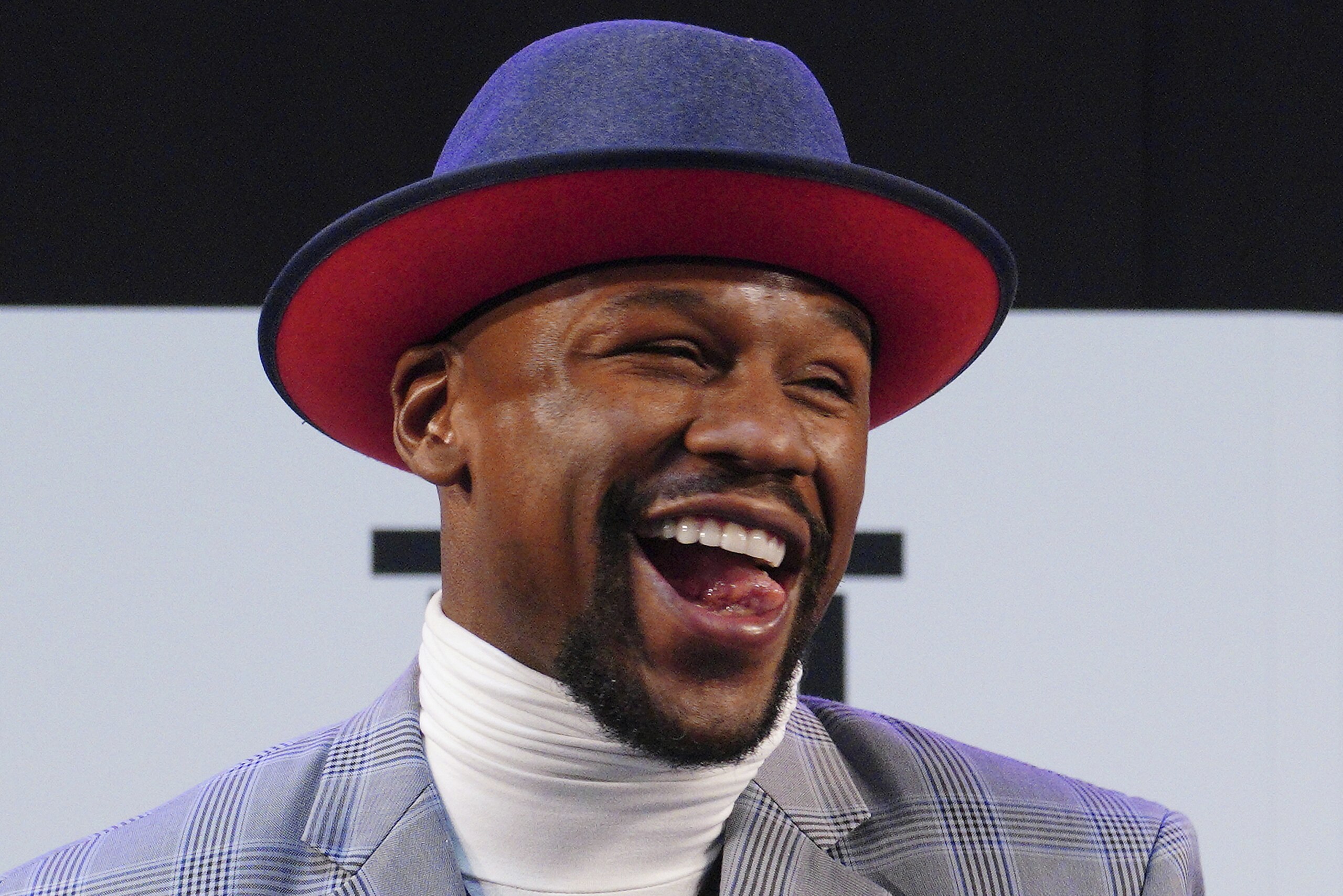 Floyd Mayweather Jr. smiles as Japanese kickboxer Tenshin Nasukawa speaks after their official weigh-in ceremony during a news conference in Saitama, north of Tokyo Sunday, Dec. 30, 2018. Mayweather is scheduled to fight in a three-round exhibition match in Japan on New Year's Eve. (AP Photo/Eugene Hoshiko)