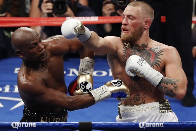 Conor McGregor, right, fights Floyd Mayweather Jr. in a super welterweight boxing match Saturday, Aug. 26, 2017, in Las Vegas. (AP Photo/Eric Jamison)