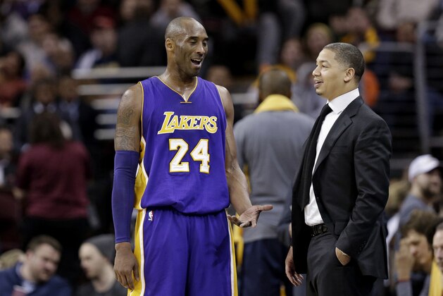 Los Angeles Lakers' Kobe Bryant, left, talks with Cleveland Cavaliers head coach Tyronn Lue in the second half of an NBA basketball game Wednesday, Feb. 10, 2016, in Cleveland. (AP Photo/Tony Dejak)