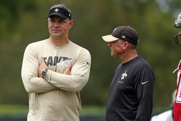 New Orleans Saints quarterbacks coach Joe Lombardi, left, and offensive coordinator Pete Carmichael, right, walk on the field during NFL football practice in Metairie, La., Tuesday, June 13, 2017. (AP Photo/Gerald Herbert)