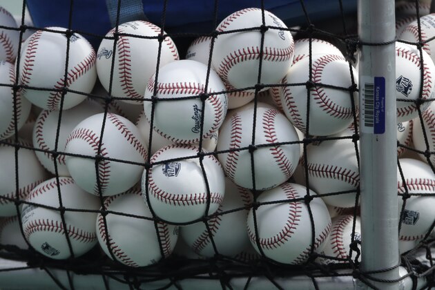 Balls marked with Cactus League spring training logos are seen in a basket during Kansas City Royals baseball practice at Kauffman Stadium Friday, July 3, 2020 in Kansas City, Mo. (AP Photo/Charlie Riedel)