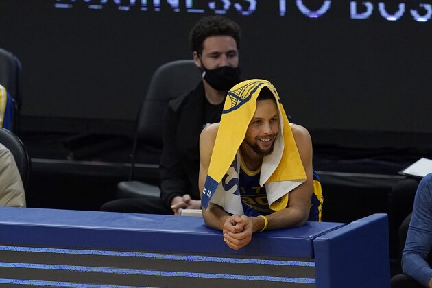 Golden State Warriors guard Stephen Curry sits in front of injured guard Klay Thompson during an NBA basketball game against the New York Knicks in San Francisco, Thursday, Jan. 21, 2021. (AP Photo/Jeff Chiu)