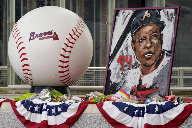 Artwork stands at Truist Park, home of the Atlanta Braves, to attend the memorial for Baseball Hall of Famer and Braves legend Hank Aaron, Tuesday, Jan. 26, 2021, in Atlanta. Just 2 1/2 weeks before his death Friday, Han 22, 2021, at age 86, Aaron joined civil rights icons to receive the COVID-19 vaccine. He wanted to spread the word to the Black community that the shots were safe in the midst of a devastating pandemic. (AP Photo/Brynn Anderson)