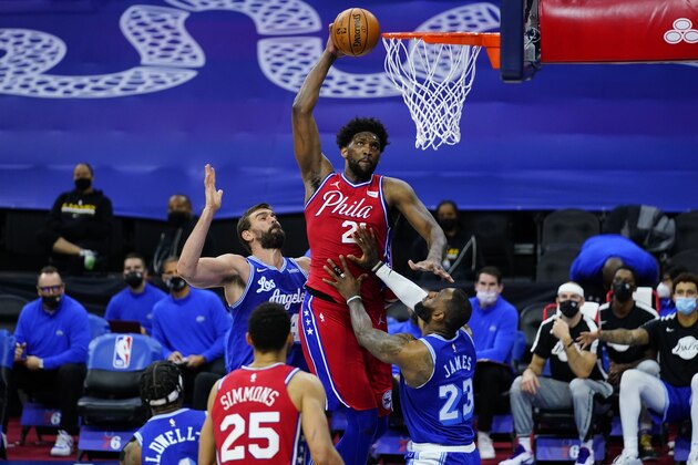 Philadelphia 76ers' Joel Embiid, center, goes up for a shot between Los Angeles Lakers' LeBron James, right, and Marc Gasol during the second half of an NBA basketball game, Wednesday, Jan. 27, 2021, in Philadelphia. (AP Photo/Matt Slocum)