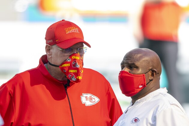 From left, Kansas City Chiefs head coach Andy Reid and Kansas City Chiefs offensive coordinator Eric Bieniemy wear masks as they talk on the field before the Chiefs take on the Miami Dolphins during an NFL football game, Sunday, Dec. 13, 2020, in Miami Gardens, Fla. (AP Photo/Doug Murray)