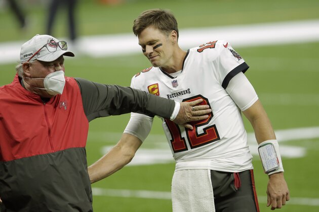 Tampa Bay Buccaneers head coach Bruce Arians, left, speaks with quarterback Tom Brady (12) before the first half of an NFL divisional round playoff football game between the New Orleans Saints and the Tampa Bay Buccaneers, Sunday, Jan. 17, 2021, in New Orleans. (AP Photo/Brett Duke)
