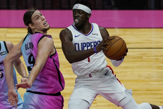 LA Clippers guard Reggie Jackson (1) grabs a rebound ahead of Miami Heat forward Kelly Olynyk (9) during the first half of an NBA basketball game, Thursday, Jan. 28, 2021, in Miami. (AP Photo/Marta Lavandier)