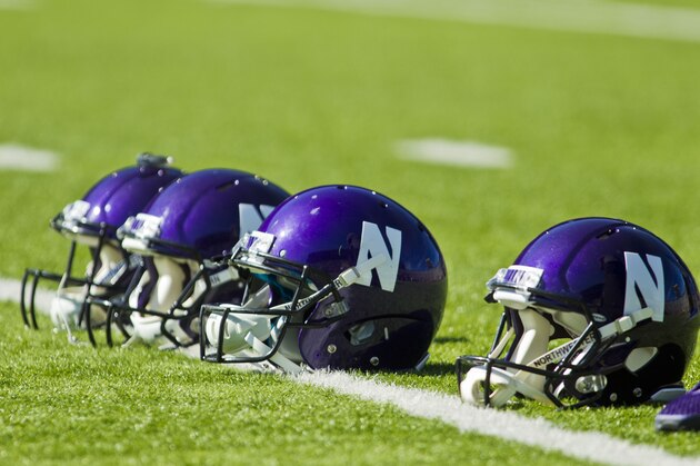 Northwestern helmets seen on the field before an NCAA college football game against Michigan at Michigan Stadium in Ann Arbor, Mich., Saturday, Oct. 10, 2015. (AP Photo/Tony Ding)