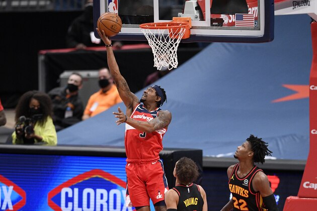 Washington Wizards guard Bradley Beal (3) goes to the basket past Atlanta Hawks guards Trae Young, bottom front, and Cam Reddish (22) during the first half of an NBA basketball game, Friday, Jan. 29, 2021, in Washington. (AP Photo/Nick Wass)