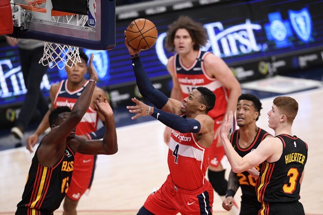 Washington Wizards guard Russell Westbrook (4) goes to the basket against Atlanta Hawks guard Kevin Huerter (3), forward John Collins (20) and center Clint Capela, left, during the second half of an NBA basketball game, Friday, Jan. 29, 2021, in Washington. (AP Photo/Nick Wass)