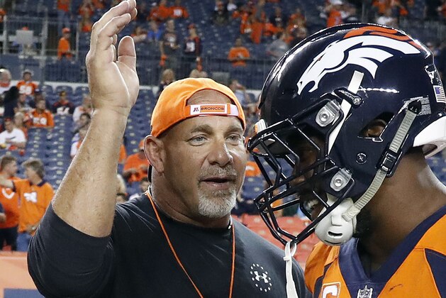 FILE - In this Sept. 11, 2017, file photo, professional wrestler Bill Goldberg, left,  greets Denver Broncos outside linebacker Von Miller prior to an NFL football game against the Los Angeles Chargers, Monday, Sept. 11, 2017, in Denver. Bill Goldberg found his toughest tag-team partner yet.