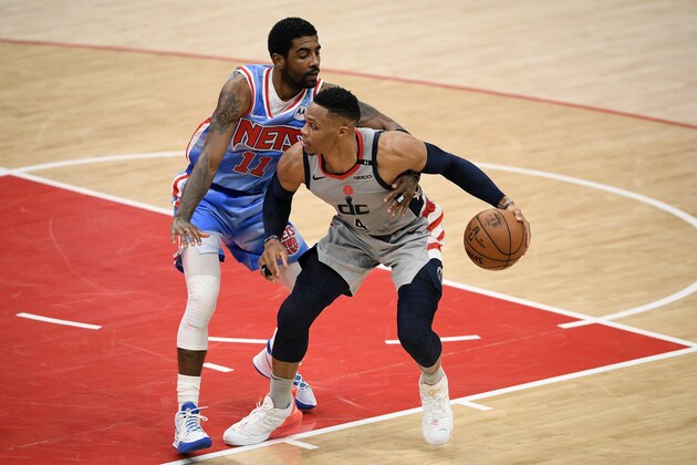 Brooklyn Nets guard Kyrie Irving (11) reaches for the ball against Washington Wizards guard Russell Westbrook (4) during the first half of an NBA basketball game, Sunday, Jan. 31, 2021, in Washington. (AP Photo/Nick Wass)