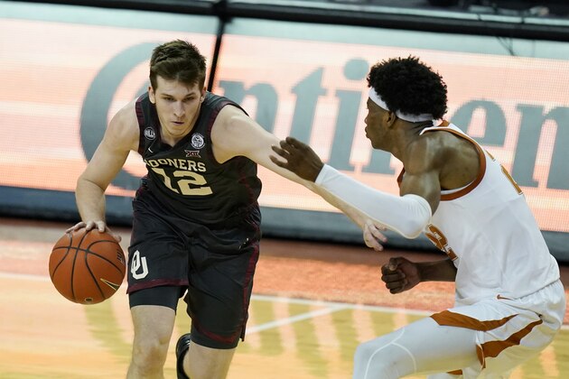 Oklahoma guard Austin Reaves (12) drives against Texas forward Kai Jones during the second half of an NCAA college basketball game Tuesday, Jan. 26, 2021, in Austin, Texas. (AP Photo/Eric Gay)