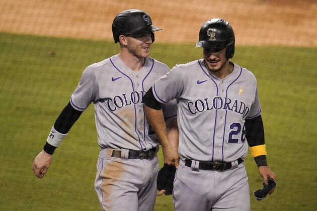 Colorado Rockies' Trevor Story, left, and Nolan Arenado walk back to the dugout after scoring on a double by Josh Fuentes during the ninth inning of a baseball game against the Los Angeles Dodgers, Saturday, Sept. 5, 2020, in Los Angeles. (AP Photo/Marcio Jose Sanchez)