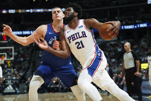 Philadelphia 76ers center Joel Embiid, front, drives past Denver Nuggets center Nikola Jokic during the second half of an NBA basketball game Friday, Nov. 8, 2019, in Denver. The Nuggets won 100-97. (AP Photo/David Zalubowski)