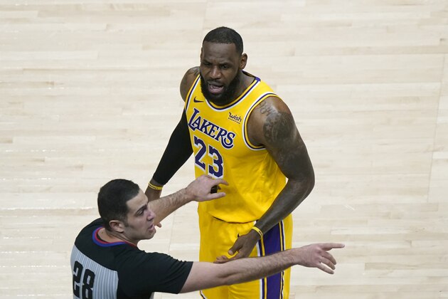 Los Angeles Lakers forward LeBron James (23) is restrained by an official as he reacts to a fan in the second half of an NBA basketball game against the Atlanta Hawks Monday, Feb. 1, 2021, in Atlanta. (AP Photo/John Bazemore)