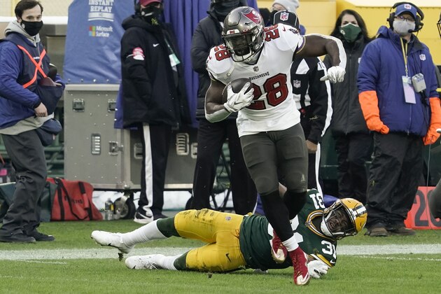 Tampa Bay Buccaneers' Leonard Fournette (28) evades a tackle by Green Bay Packers' Adrian Amos to score on a 20-yard touchdown run during the first half of the NFC championship NFL football game in Green Bay, Wis., Sunday, Jan. 24, 2021. (AP Photo/Morry Gash)