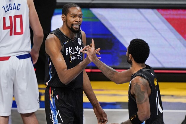 Brooklyn Nets forward Kevin Durant (7) congratulates guard Kyrie Irving (11) during the fourth quarter of the team's NBA basketball game against the Los Angeles Clippers, Tuesday, Feb. 2, 2021, in New York. (AP Photo/Kathy Willens)