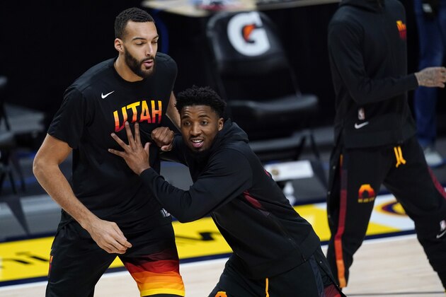 Utah Jazz guard Donovan Mitchell (45) jokes with Utah Jazz center Rudy Gobert (27) in the first half of an NBA basketball game Sunday, Jan. 31, 2021, in Denver. (AP Photo/David Zalubowski)