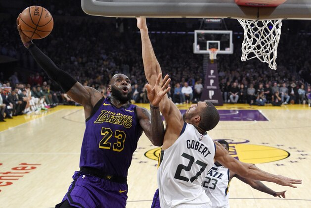 Los Angeles Lakers forward LeBron James, left, shoots as Utah Jazz center Rudy Gobert, of France, defends during the second half of an NBA basketball game Friday, Nov. 23, 2018, in Los Angeles. (AP Photo/Mark J. Terrill)