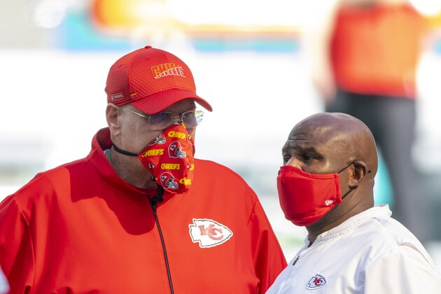 From left, Kansas City Chiefs head coach Andy Reid and Kansas City Chiefs offensive coordinator Eric Bieniemy wear masks as they talk on the field before the Chiefs take on the Miami Dolphins during an NFL football game, Sunday, Dec. 13, 2020, in Miami Gardens, Fla. (AP Photo/Doug Murray)