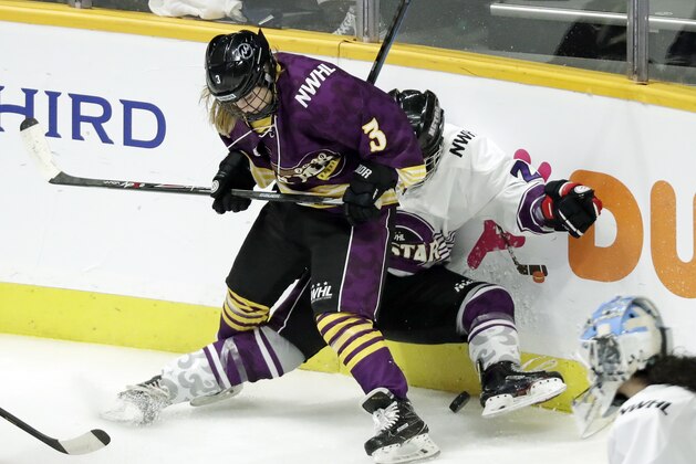 FILE- In this Feb. 10, 2019, file photo, Jonna Curtis, left, a forward on Team Stecklein, battles for the puck with Michelle Picard, right, a defender on Team Szabados, during the NWHL All-Star Hockey Game in Nashville, Tenn. The women's hockey league thinks it can make it work with the same kind of COVID-19 testing the NBA used in its Disney World bubble. Players, coaches and staff will essentially be limited to hotel and Herb Brooks Arena, the site of the 1980 “Miracle on Ice” that serves as a historic setting for a unique season.  (AP Photo/Mark Humphrey, File)