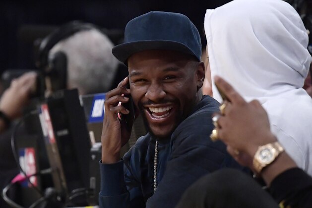 Boxer Floyd Mayweather Jr. talks on the phone during the second half of an NBA basketball game between the Los Angeles Lakers and the Minnesota Timberwolves on Thursday, Jan. 24, 2019, in Los Angeles. The Timberwolves won 120-105. (AP Photo/Mark J. Terrill)