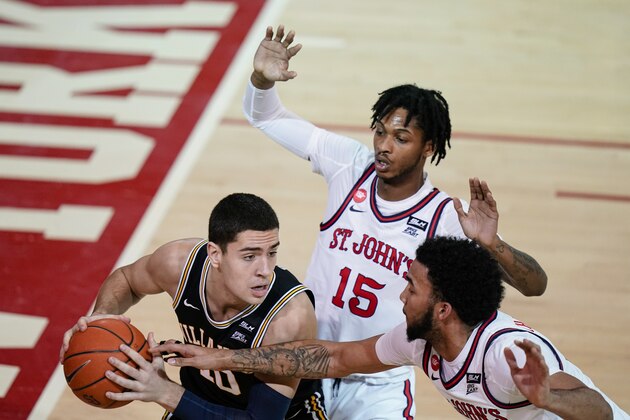 Villanova's Cole Swider (10) protects the ball from St. John's Julian Champagnie and Vince Cole (15) during the first half of an NCAA college basketball game Wednesday, Feb. 3, 2021, in New York. (AP Photo/Frank Franklin II)