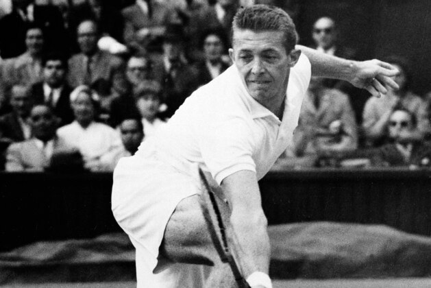FILE - Tony Trabert makes a backhand return against Denmark's Kurt Nielsen in their men's singles championship match at Wimbledon, in this July 1, 1955, file photo. Trabert won the match. Tony Trabert, a five-time Grand Slam singles champion and former No. 1 player who went on to successful careers as a Davis Cup captain, broadcaster and executive, has died. He was 90 years old. The Tennis Hall of Famer's death Wednesday night, Feb. 3, 2021, at his home in Ponte Vedra Beach, Florida, was confirmed by his daughter, Brooke Trabert Dabkowski. (AP Photo/File)