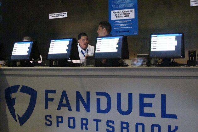 This July 14, 2018 file photo shows workers at the FanDuel sports book at the Meadowlands Racetrack in East Rutherford, N.J., preparing to take bets moments before it opened. FanDuel on Nov. 30 paid off on bets customers made on Alabama to win the national college football championship a month before the game is played. (AP Photo/Wayne Parry, File)
