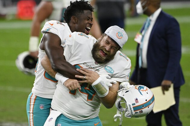 Miami Dolphins wide receiver Isaiah Ford, left, celebrates with quarterback Ryan Fitzpatrick after defeating the Las Vegas Raiders in an NFL football game, Saturday, Dec. 26, 2020, in Las Vegas. (AP Photo/David Becker)