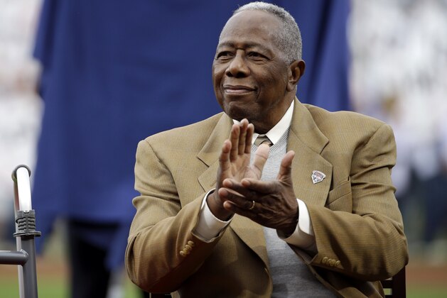 FILE- In this April 8, 2014, file photo, Hank Aaron applauds during a ceremony celebrating the 40th anniversary of his 715th home run before the start of a baseball game between the Atlanta Braves and the New York Mets in Atlanta. The former Braves’ slugger met with Little League sensation Mo’ne Davis and her youth league teammates on Tuesday, June 23, 2015, who got a tour of Turner Field. (AP Photo/David Goldman, File)
