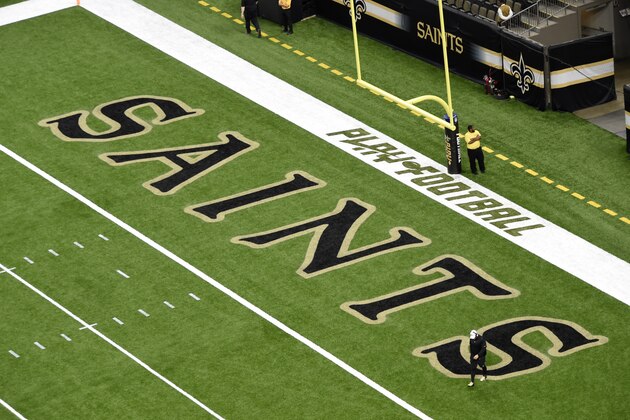 The New Orleans Saints logo and the Play Football logo are seen on the field before an NFL preseason football game in New Orleans, Thursday, Aug. 29, 2019. (AP Photo/Bill Feig)