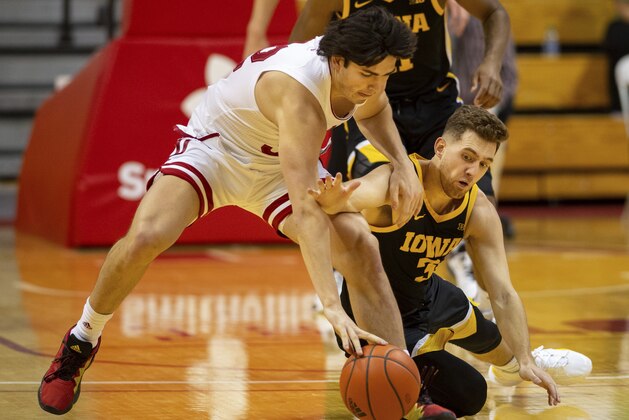 Indiana guard Trey Galloway (32), left, and Iowa guard Jordan Bohannon (3) battle for the ball during the first half of an NCAA college basketball game, Sunday, Feb. 7, 2021, in Bloomington, Ind. (AP Photo/Doug McSchooler)