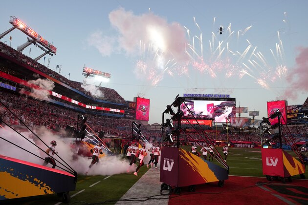 Tampa Bay Buccaneers players run onto the field before the NFL Super Bowl 55 football game between the Kansas City Chiefs and Buccaneers, Sunday, Feb. 7, 2021, in Tampa, Fla. (AP Photo/Chris O'Meara)