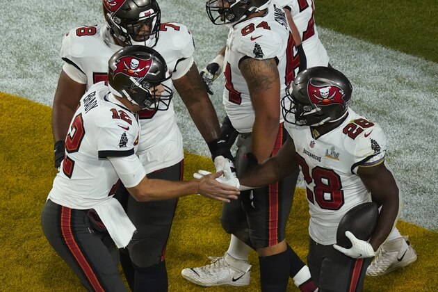 Tampa Bay Buccaneers' Leonard Fournette (28) celebrates a touchdown run with quarterback Tom Brady (12) during the second half of the NFL Super Bowl 55 football game against the Kansas City Chiefs, Sunday, Feb. 7, 2021, in Tampa, Fla. (AP Photo/Charlie Riedel)