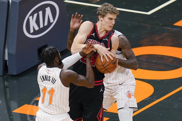 Orlando Magic forward James Ennis III (11) strips the ball from Chicago Bulls forward Lauri Markkanen, center, during the first half of an NBA basketball game, Friday, Feb. 5, 2021, in Orlando, Fla. (AP Photo/John Raoux)