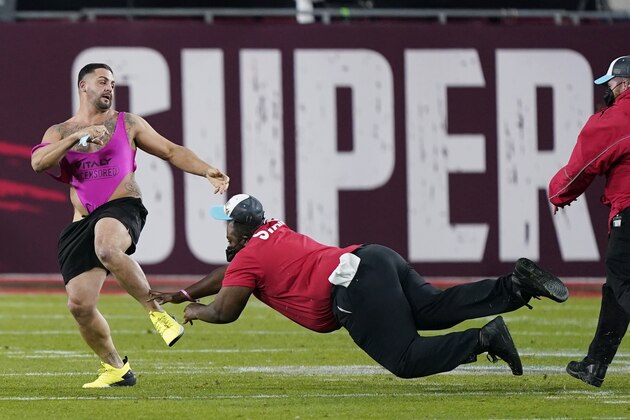Security tries to grab a fan on the field during the second half of the NFL Super Bowl 55 football game between the Tampa Bay Buccaneers and the Kansas City Chiefs, Sunday, Feb. 7, 2021, in Tampa, Fla. (AP Photo/Mark Humphrey)