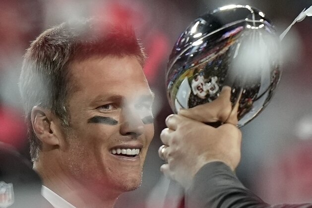 El quarterback Tom Brady de los Buccaneers de Tampa Bay observa el trofeo del Super Bowl al celebrar la victoria ante los Chiefs de Kansas City, el domingo 7 de febrero de 2021, en Tampa, Florida. (AP Foto/David J. Phillip)