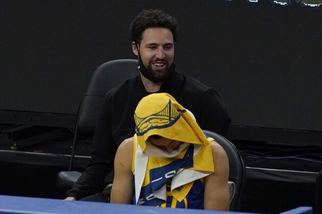 Golden State Warriors guard Stephen Curry sits in front of injured guard Klay Thompson during an NBA basketball game against the New York Knicks in San Francisco, Thursday, Jan. 21, 2021. (AP Photo/Jeff Chiu)