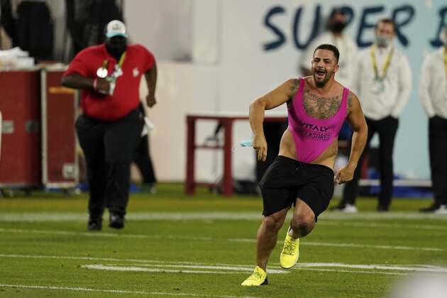 A fan runs on the field during the second half of the NFL Super Bowl 55 football game between the Tampa Bay Buccaneers and the Kansas City Chiefs, Sunday, Feb. 7, 2021, in Tampa, Fla. The Tampa Bay Buccaneers defeated the Kansas City Chiefs 31-9. (AP Photo/Steve Luciano)
