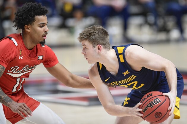 West Virginia's Sean McNeil (22) controls the ball against Texas Tech's Kyler Edwards (11) during the first half of an NCAA college basketball game in Lubbock, Texas, Tuesday, Feb. 9, 2021. (AP Photo/Justin Rex)