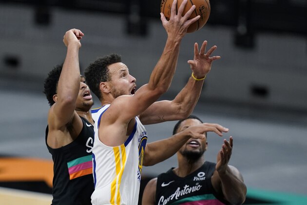 Golden State Warriors guard Stephen Curry (30) scores past San Antonio Spurs forward Keldon Johnson, left, and forward Rudy Gay, right, during the second half of an NBA basketball game in San Antonio, Tuesday, Feb. 9, 2021. (AP Photo/Eric Gay)
