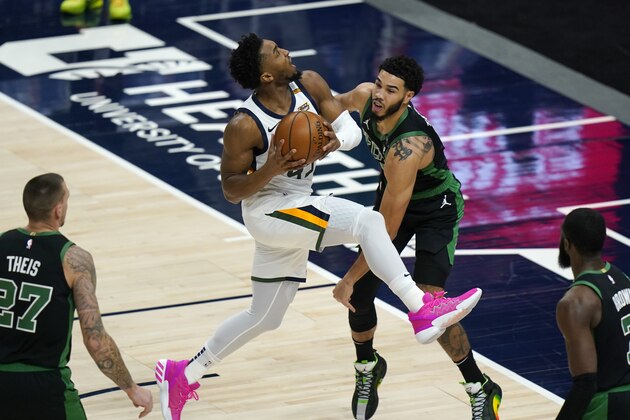 Utah Jazz guard Donovan Mitchell, left, goes to the basket as Boston Celtics forward Jayson Tatum, right, defends in the first half during an NBA basketball game Tuesday, Feb. 9, 2021, in Salt Lake City. (AP Photo/Rick Bowmer)