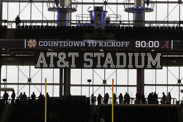 Silhouettes of fans are seen walking along the upper level concourses at AT&T Stadium before the Rose Bowl NCAA college football game between Notre Dame and Alabama in Arlington, Texas, Friday, Jan. 1, 2021. (AP Photo/Ron Jenkins)