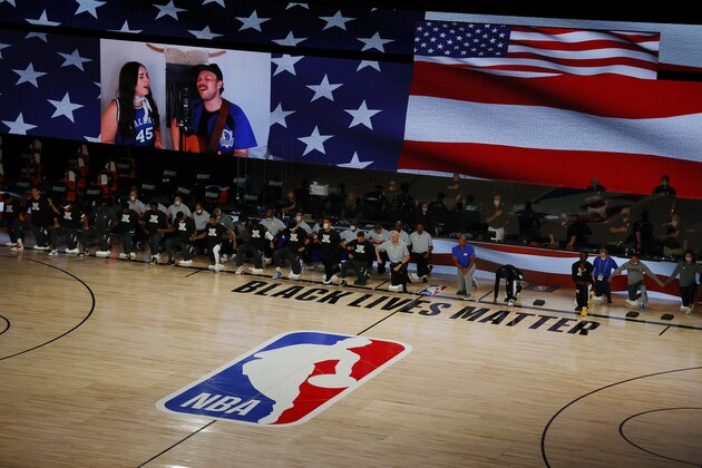 Players take a knee during the national anthem before Game 4 of an NBA basketball first-round playoff series between the Los Angeles Clippers and the Dallas Mavericks, Sunday, Aug. 23, 2020, in Lake Buena Vista, Fla. (Kevin C. Cox/Pool Photo via AP)
